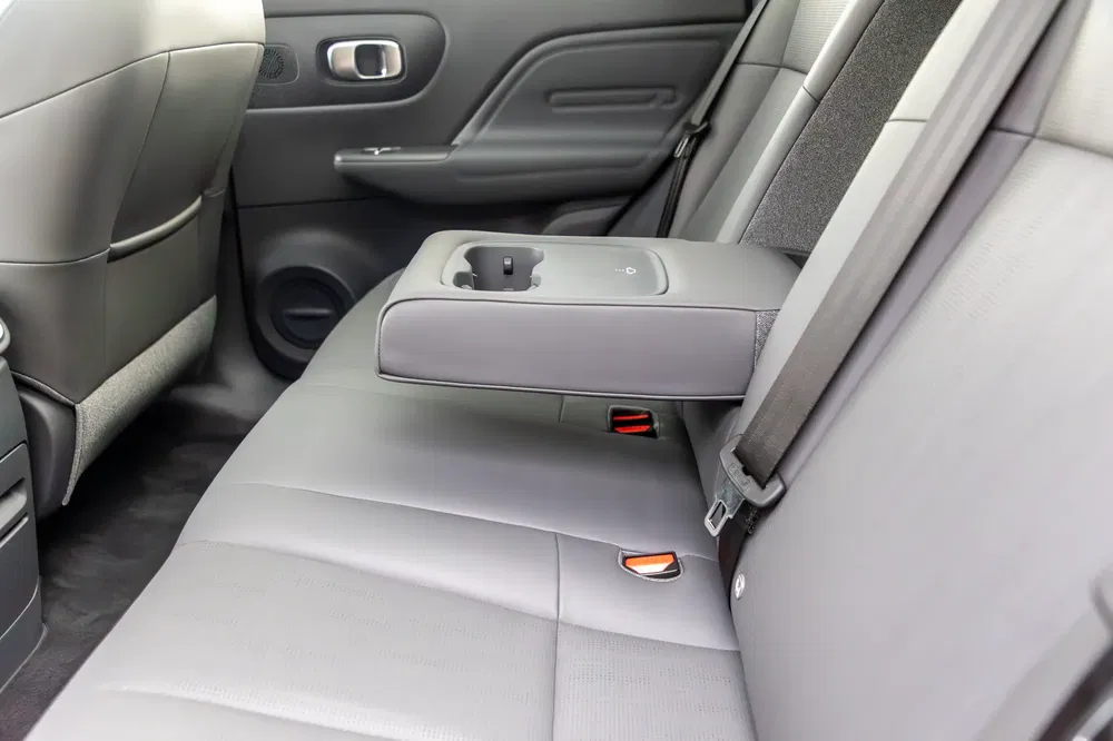 Intérieur d'une voiture avec accoudoir central rabattable et porte-gobelets arrière.