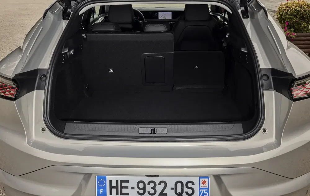 Coffre spacieux de la Peugeot avec plaque française, montrant l'intérieur moderne et dégagé.