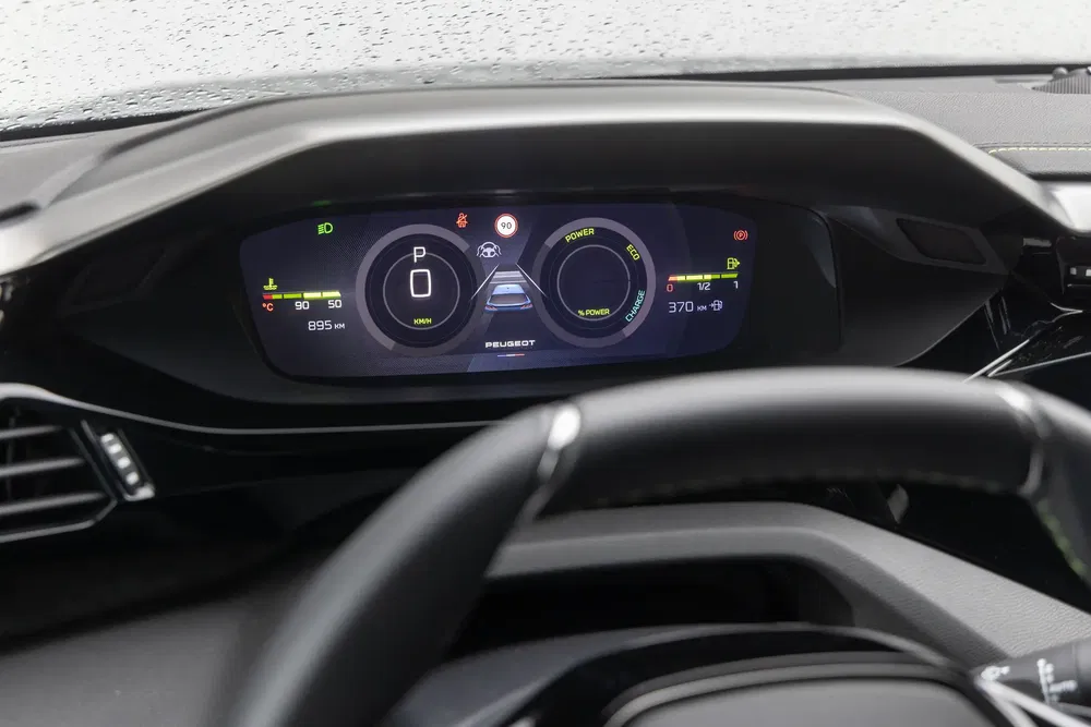 Digitaal dashboard van een Peugeot met snelheid- en energieverbruikweergave.