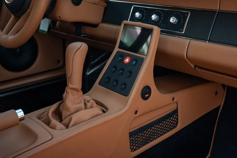 Luxeautointerieur met leren versnellingspook, touchscreen en bedieningselementen.