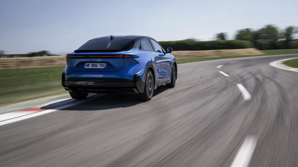 Peugeot Inception bleue en virage sur circuit, démontrant sa maniabilité et performance.