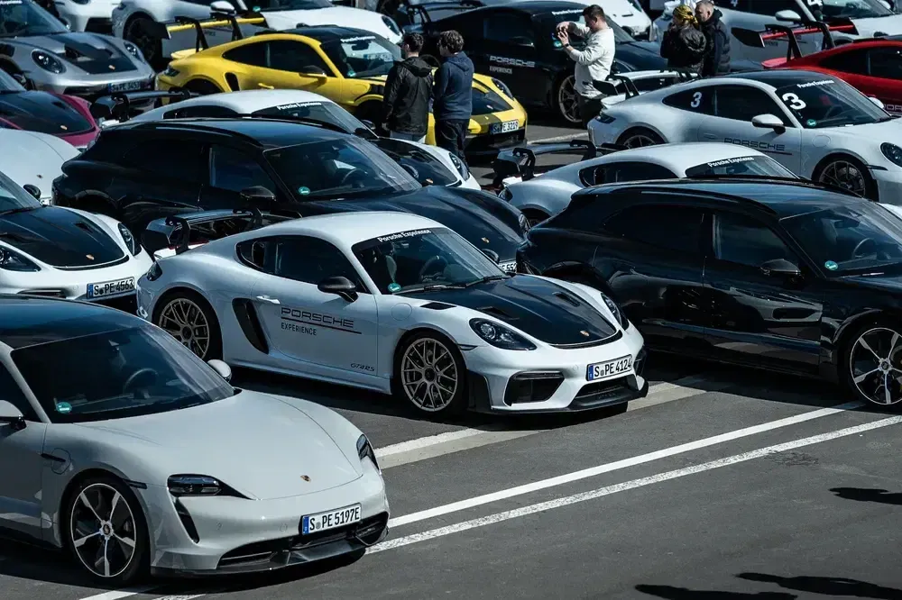 {"fr":"Rassemblement de voitures de sport Porsche, modèles visibles: 718, 911, Taycan sur un parking.","nl":"Porsche sportautomeeting, zichtbare modellen: 718, 911, Taycan op een parkeerterrein."}
