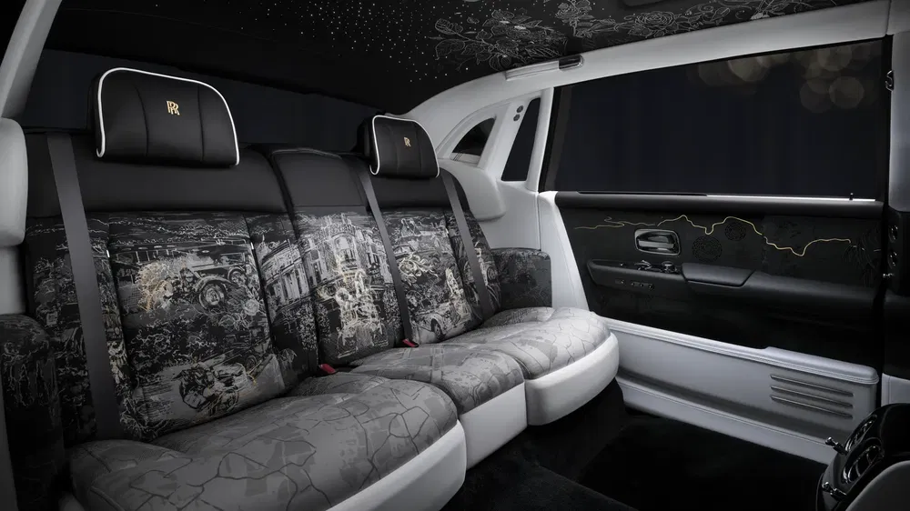 Intérieur luxueux d'une Rolls-Royce avec sièges arrière artistiques et étoilé au plafond.