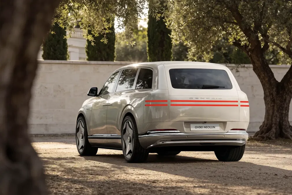 Vue arrière du SUV Genesis GV90 Neolun blanc stationné sous des arbres, design moderne.