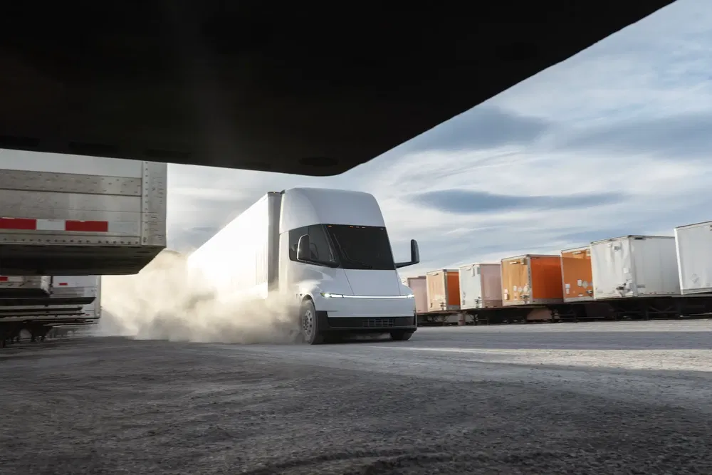Camion électrique Tesla Semi roulant à vive allure sur une route poussiéreuse.