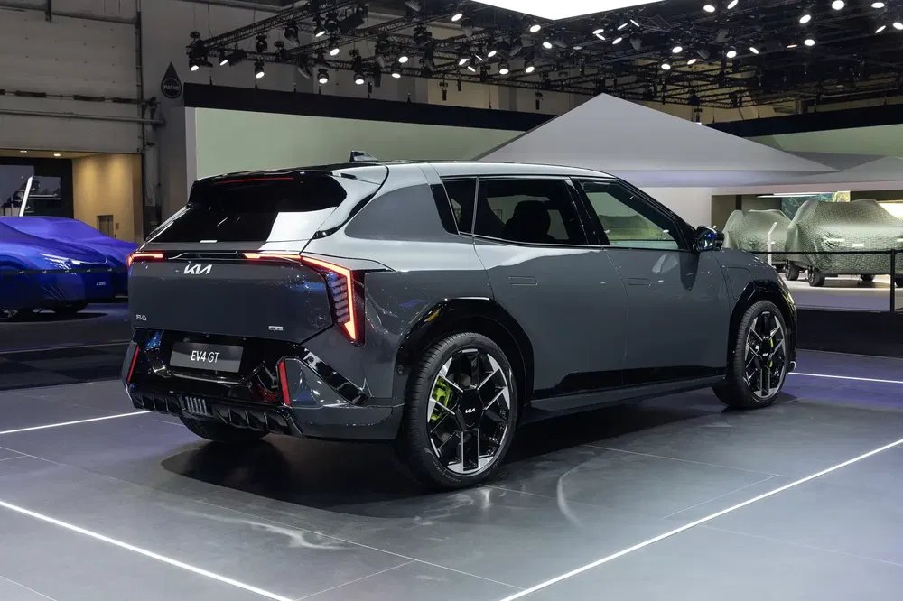 SUV Kia EV4 GT gris exposé sous des projecteurs au salon de l'automobile.