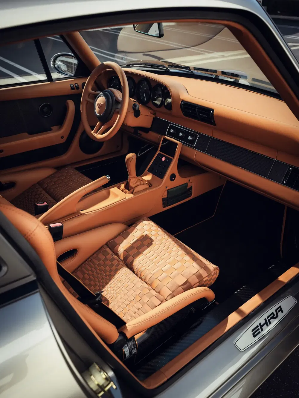 Vintage Porsche interieur, gevlochten bruin leer, elegant ontwerp, hoogwaardige afwerking.