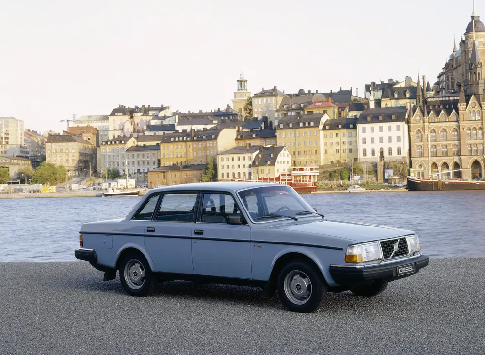 Volvo 240 classique sur fond de skyline urbain au bord de l'eau.