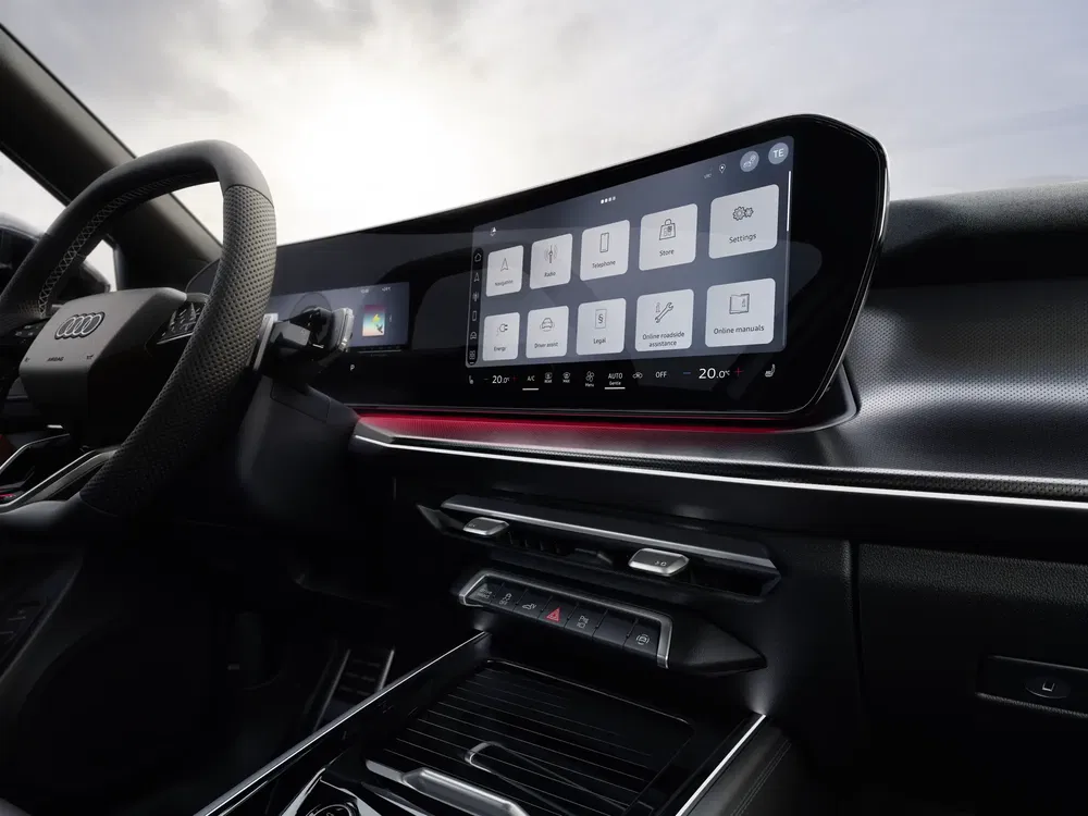 Intérieur Audi moderne avec écran tactile large, volant en cuir, éclairage LED rouge.
