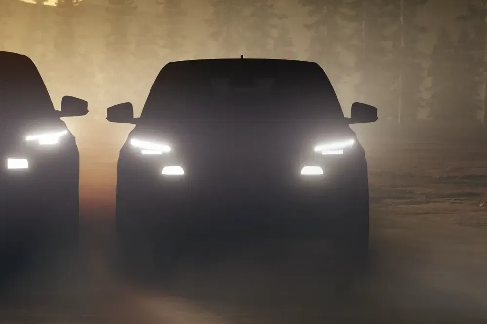 Deux voitures aux phares allumés dans la pénombre, silhouette mystique en forêt brumeuse.