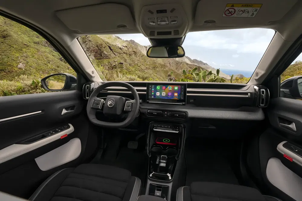 Moderne SUV-interieur met digitaal dashboard en panoramisch uitzicht op de bergen.