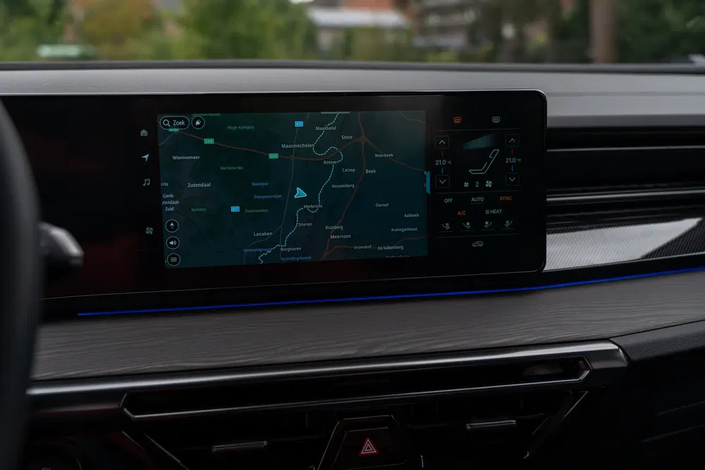 Modern navigatiescherm in auto met kaart en klimaatbedieningen.