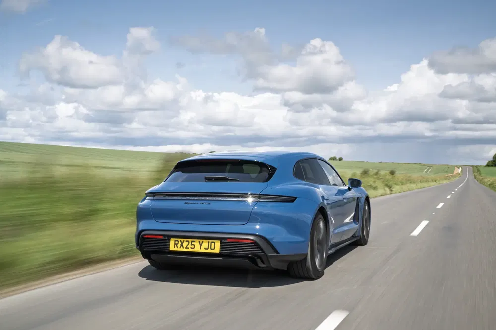 {"fr":"Porsche Taycan bleu roulant sur une route de campagne sous un ciel nuageux.","nl":"Blauwe Porsche Taycan rijdt op een landweg onder een bewolkte hemel."}