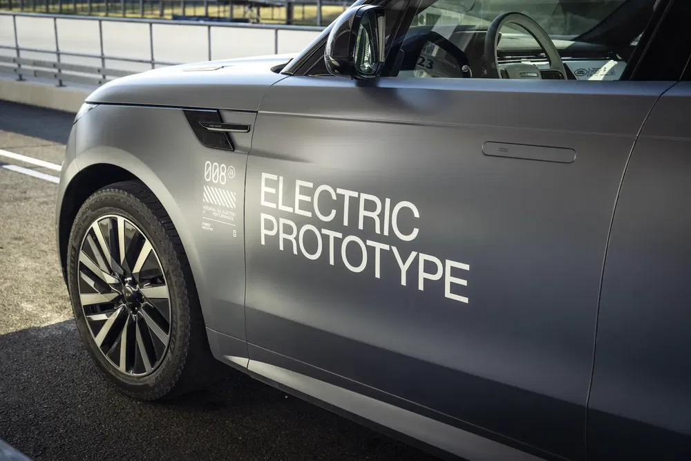 Prototype électrique Land Rover sur piste, gros plan sur le côté du véhicule.