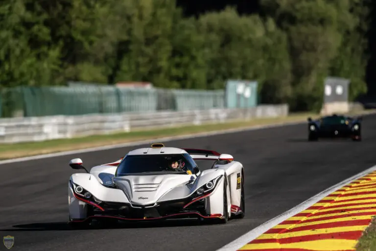 Witte Praga Bohema hypercar racet met hoge snelheid op een circuit.
