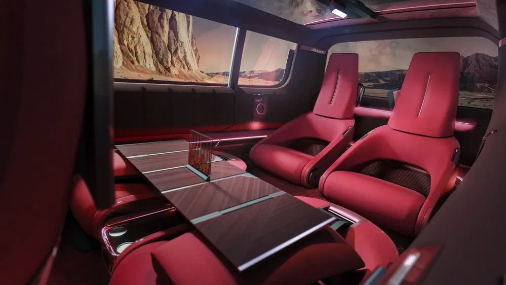 Intérieur luxueux de concept-car électrique avec sièges rouges et table centrale moderne.