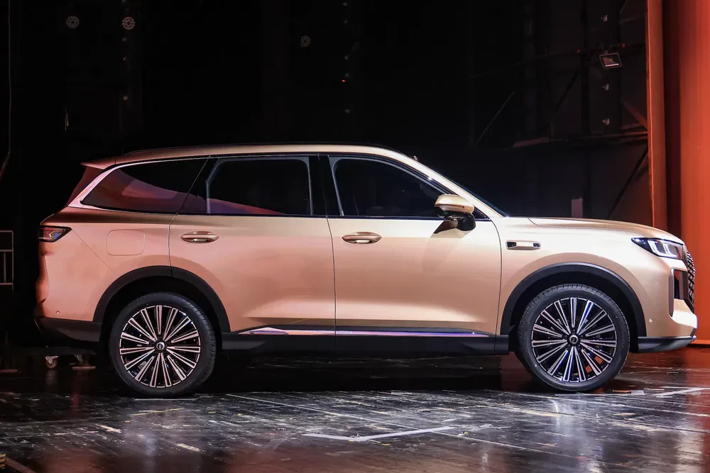 2024 Geely Galaxy L7 SUV doré élégamment profilé sur fond sombre.