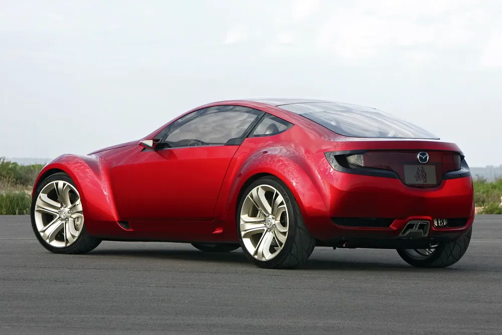 Mazda concept car rouge à deux portes avec des pneus larges sur piste.