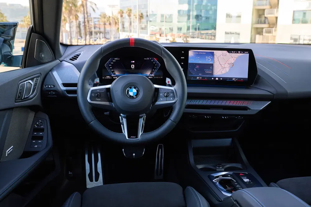 Intérieur de la BMW iX1 avec écran tactile moderne et volant sportif.