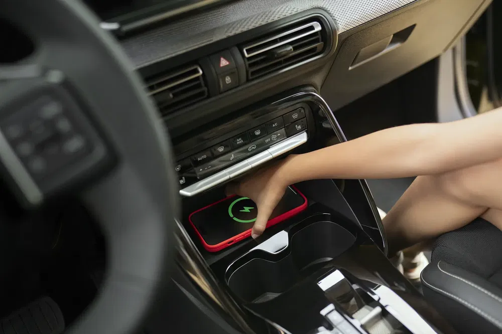 Draadloze opladen van een smartphone in moderne auto, hand pakt de telefoon.