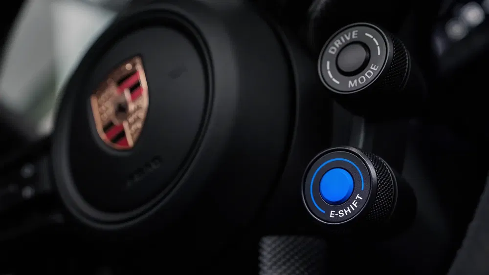 Volant Porsche avec bouton E-Shift et Drive Mode, intérieur de voiture de sport.
