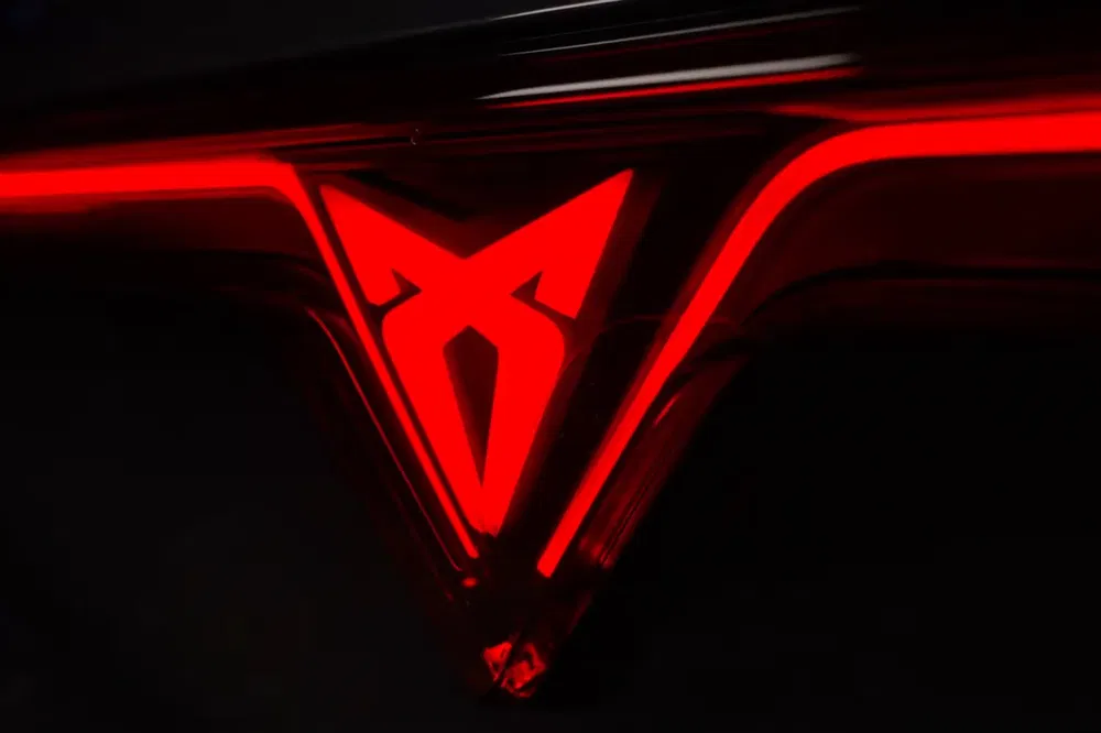 {"fr":"Logo Cupra éclairé en rouge sur une voiture moderne, design futuriste et sportif.","nl":"Verlicht Cupra-logo in rood op moderne auto, futuristisch en sportief ontwerp."}