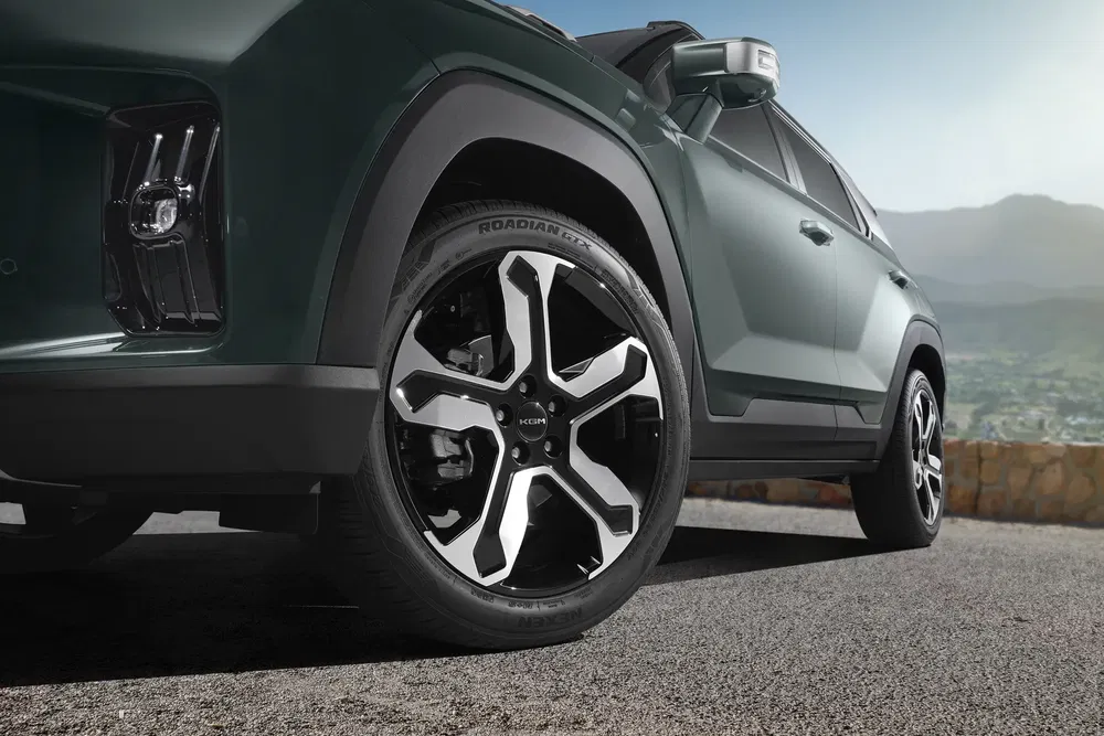 Close-up van een Hyundai SUV met moderne chromen velgen in een bergachtige omgeving.