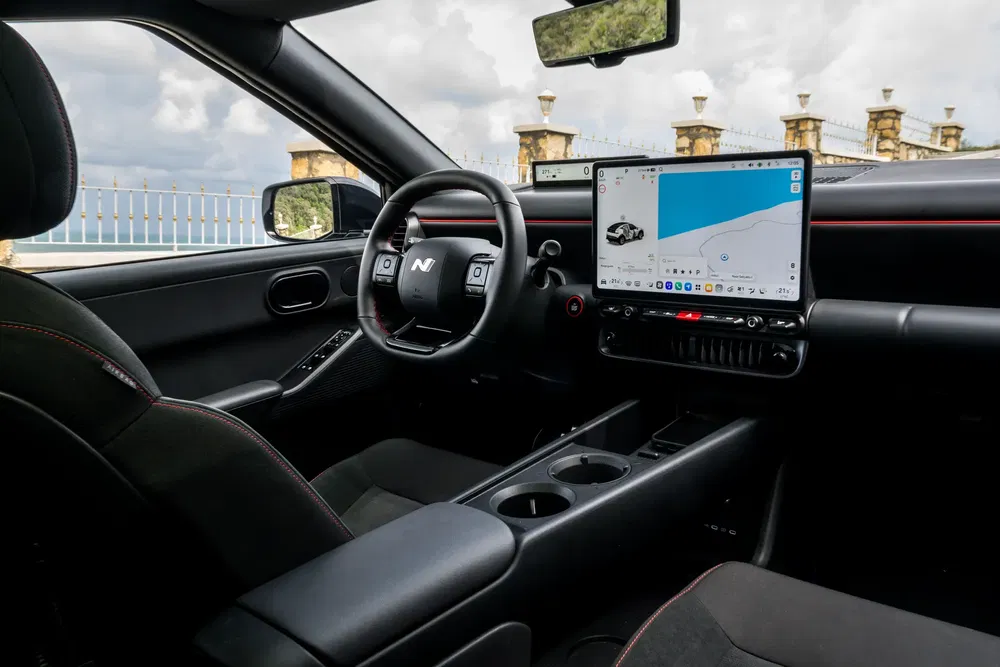 Moderne interieur van een Hyundai auto met sportief stuur en groot digitaal scherm.