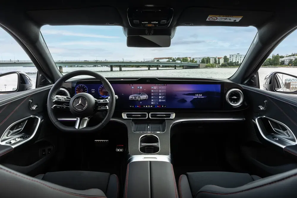 Moderne interieur van een Mercedes met groot touchscreen en stijlvol ontworpen stuurwiel.
