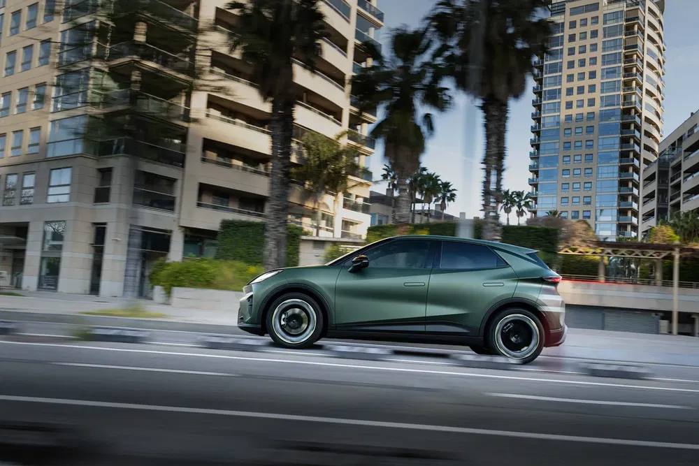 SUV moderne circulant en ville, bâtiments et palmiers en arrière-plan flou.