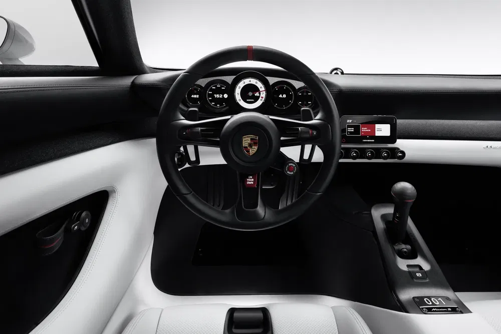 Stuur en dashboard van moderne Porsche, stijlvol zwart-wit interieur.