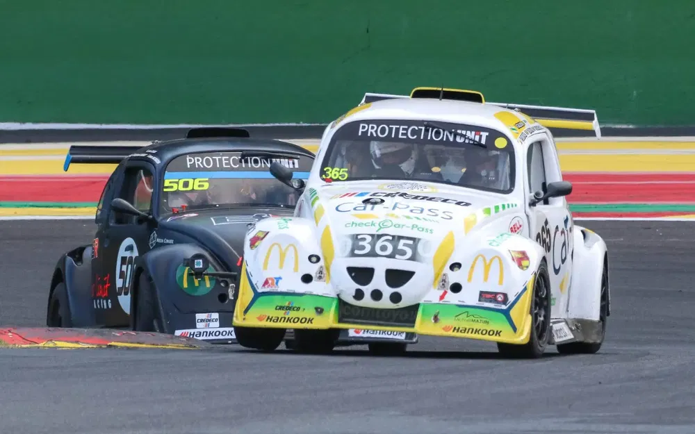 {"fr":"Deux voitures de course VW Coccinelle aux couleurs vives sur une piste de course.","nl":"Twee raceauto's VW Kever in levendige kleuren op een racetrack."}