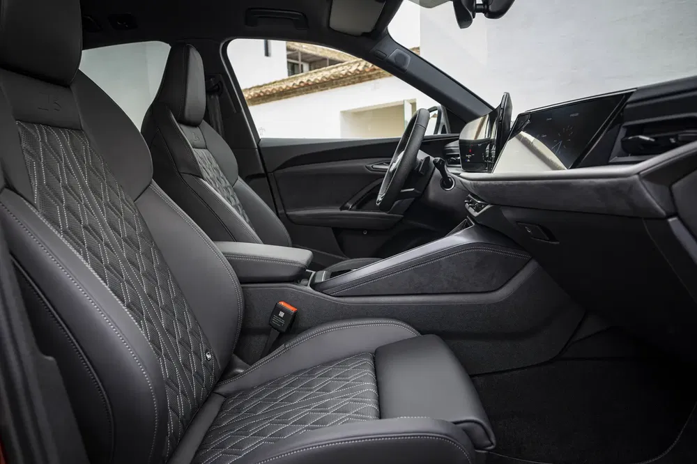 Sièges en cuir Audi avec surpiqûres diamant, intérieur spacieux et écran tactile moderne.