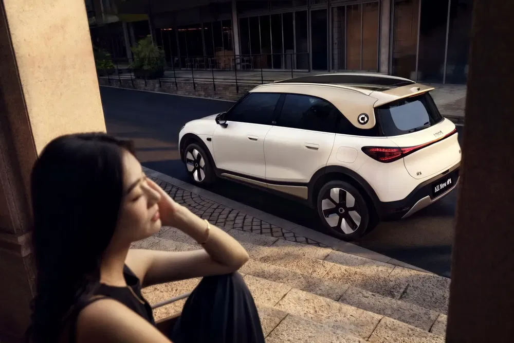 SUV Smart #1 blanc garé en ville avec une femme en avant-plan.