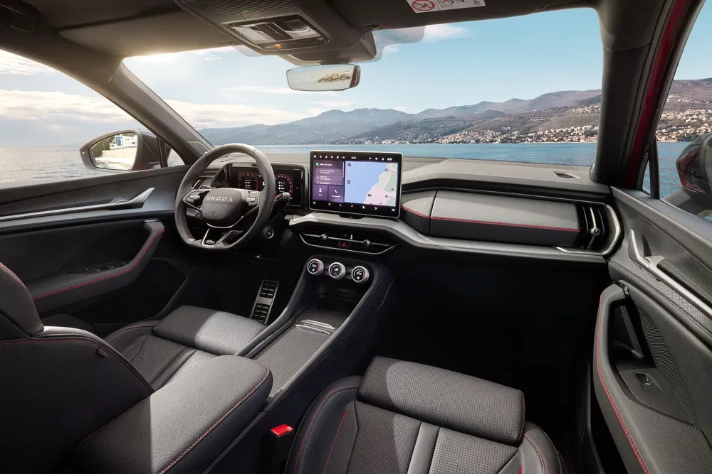 Intérieur moderne d'une Škoda avec écran tactile, vue panoramique sur l'océan.