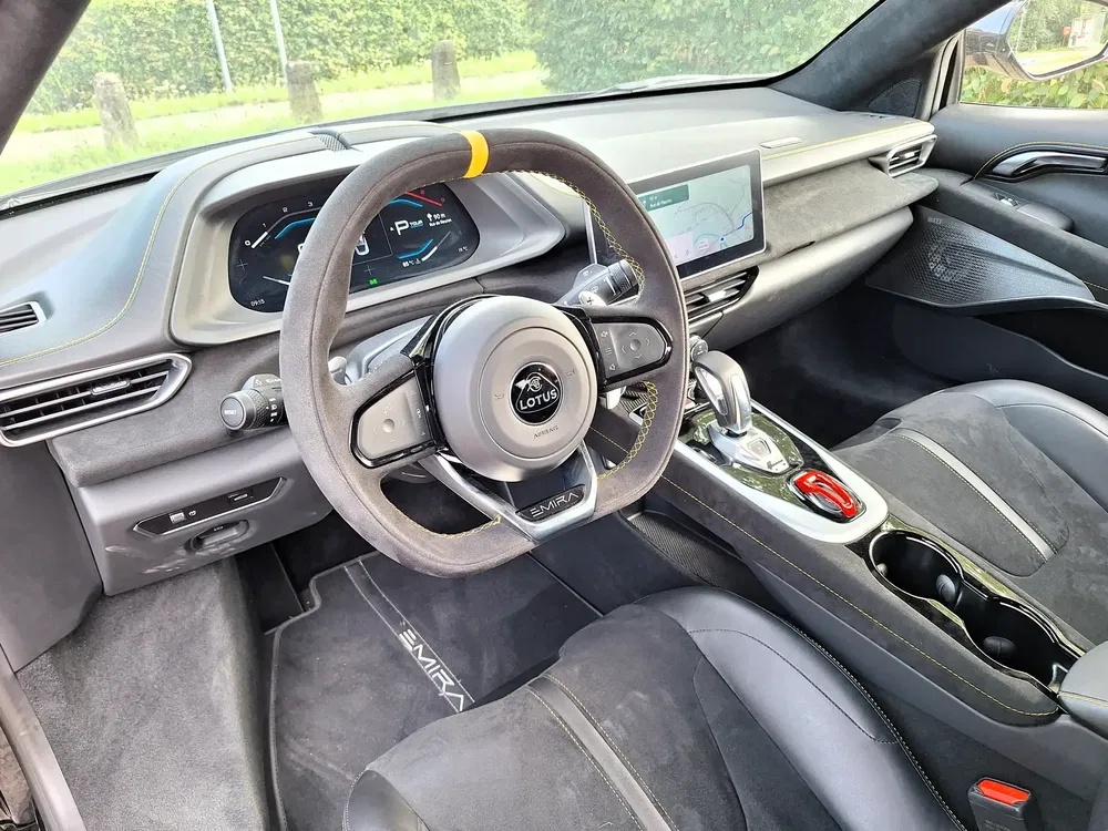 Interieur van een Lotus Emira met sportstuur en modern digitaal dashboard.