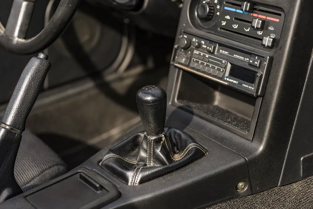 Intérieur de voiture classique avec levier de vitesse manuel et tableau de bord rétro.