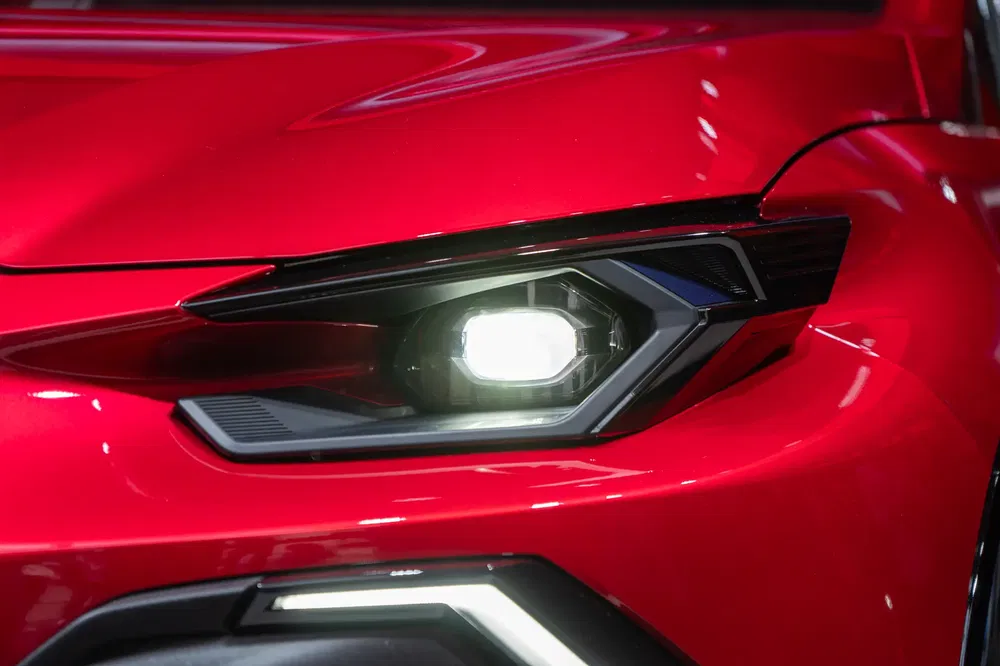 Close-up van de moderne koplamp van een stijlvolle rode compacte Lexus.