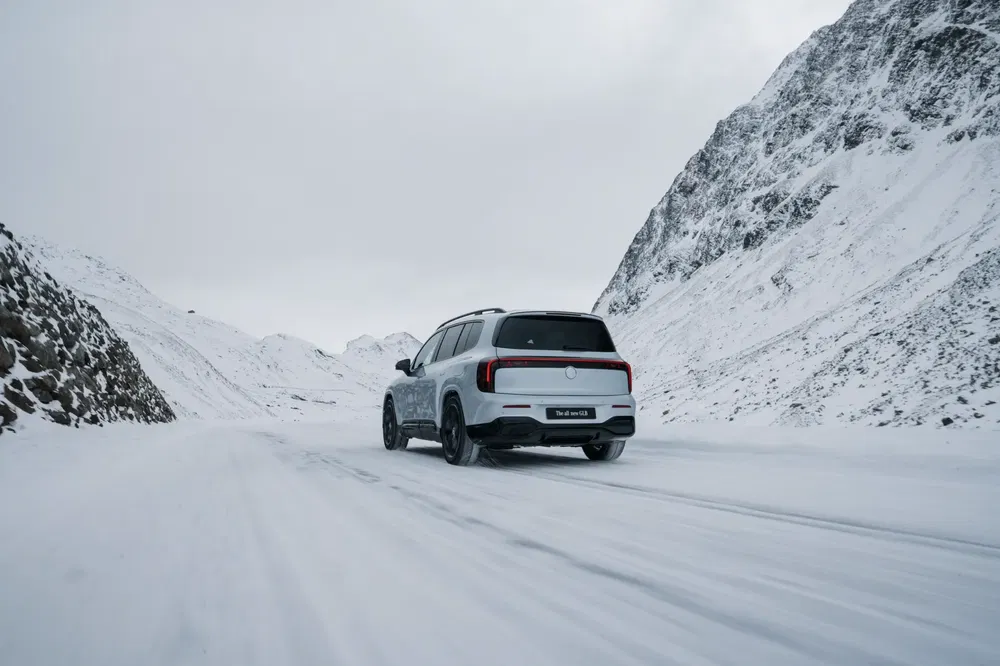 SUV Mercedes-Benz sur route enneigée, entouré de montagnes hivernales pittoresques.