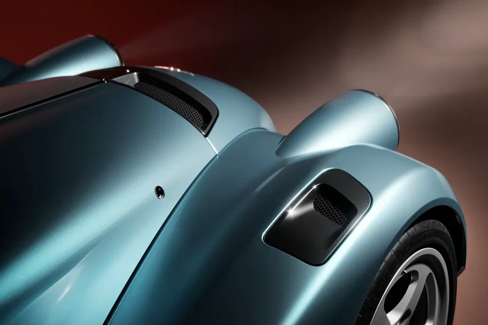 Détails du capot d'une Porsche 911 classique bleu métallique avec prises d'air noires.