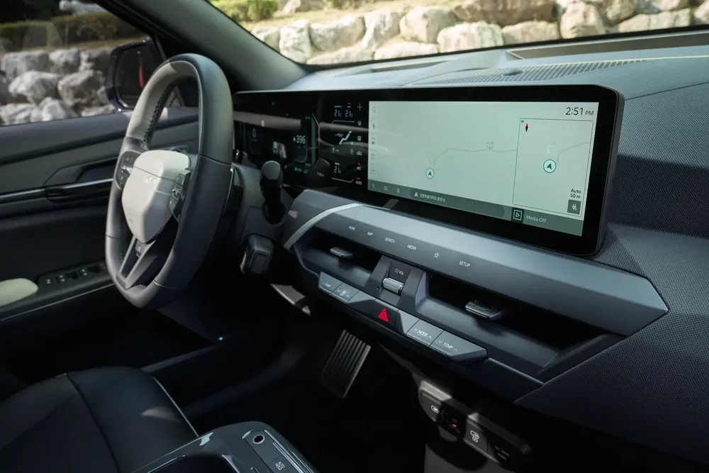 Modern interieur van de Kia EV5 met digitaal scherm en stuur.