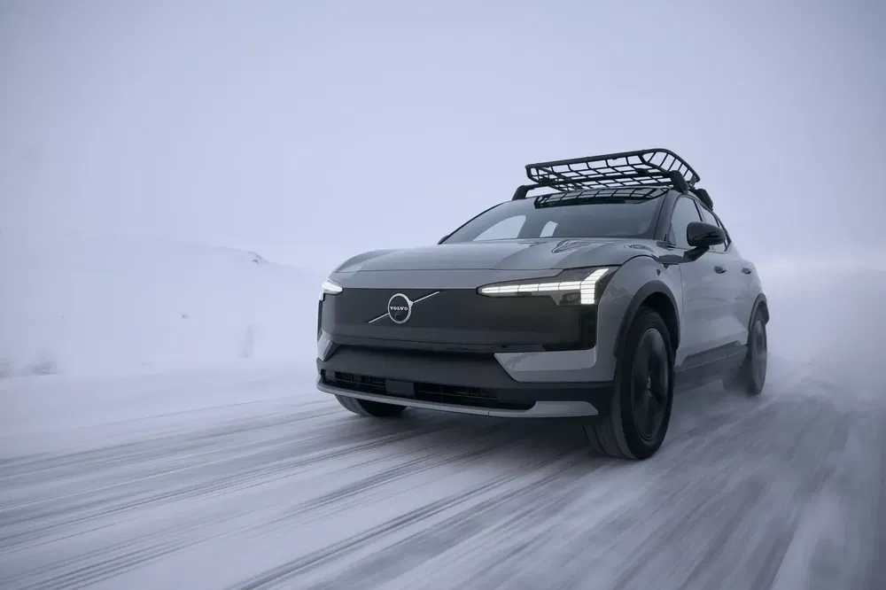Volvo XC40 noir sur route enneigée, avec galerie de toit pour aventure hivernale.