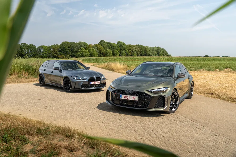 Audi RS6 C8 en BMW M3 stationwagen op een landelijke weg.