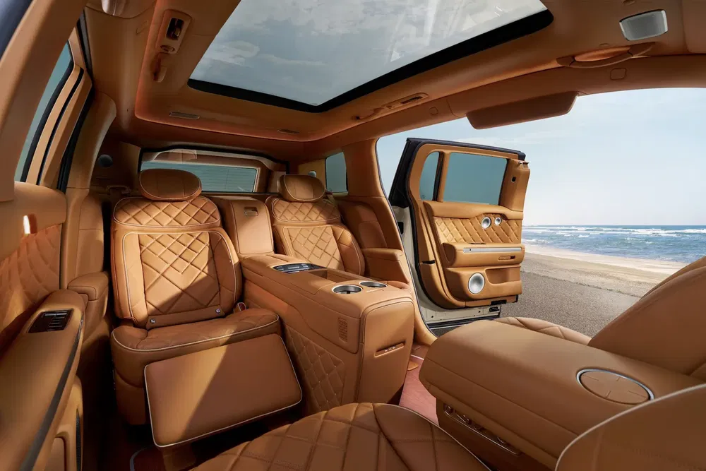 Intérieur luxueux de SUV Bentley Bentayga avec sièges en cuir brun et vue sur la mer.
