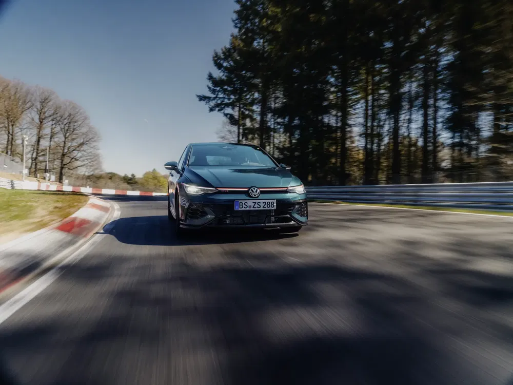 {"fr":"Volkswagen Golf GTI roulant à grande vitesse sur circuit sinueux entouré de forêt.","nl":"Volkswagen Golf GTI rijdt snel op bochtig circuit omringd door bos."}