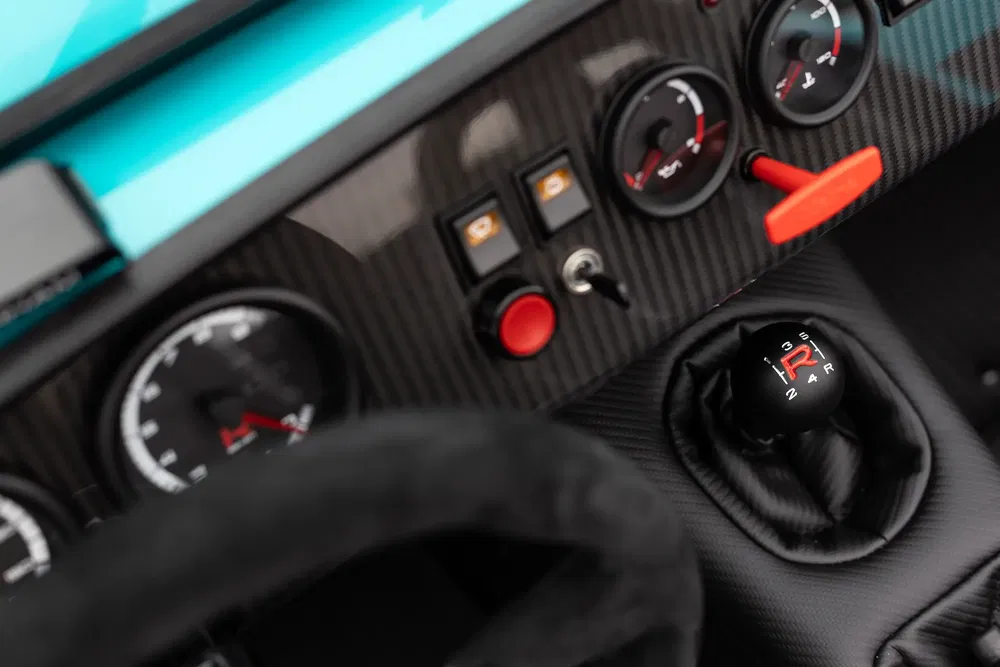 Tableau de bord en fibre de carbone avec levier de vitesse manuel et jauges analogiques.