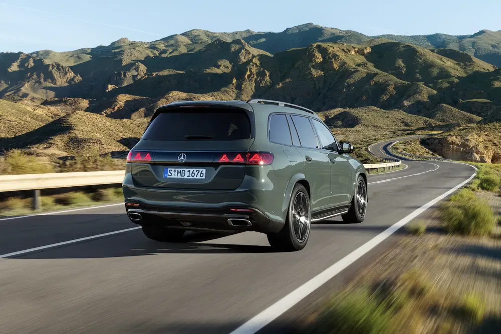 Mercedes-Benz GLS en route montagneuse, paysage de collines rocheuses en arrière-plan.