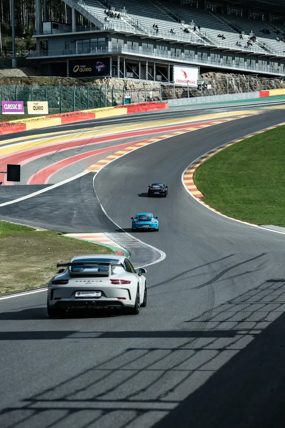 Voitures de sport Porsche en piste au circuit de Spa-Francorchamps, Belgique.