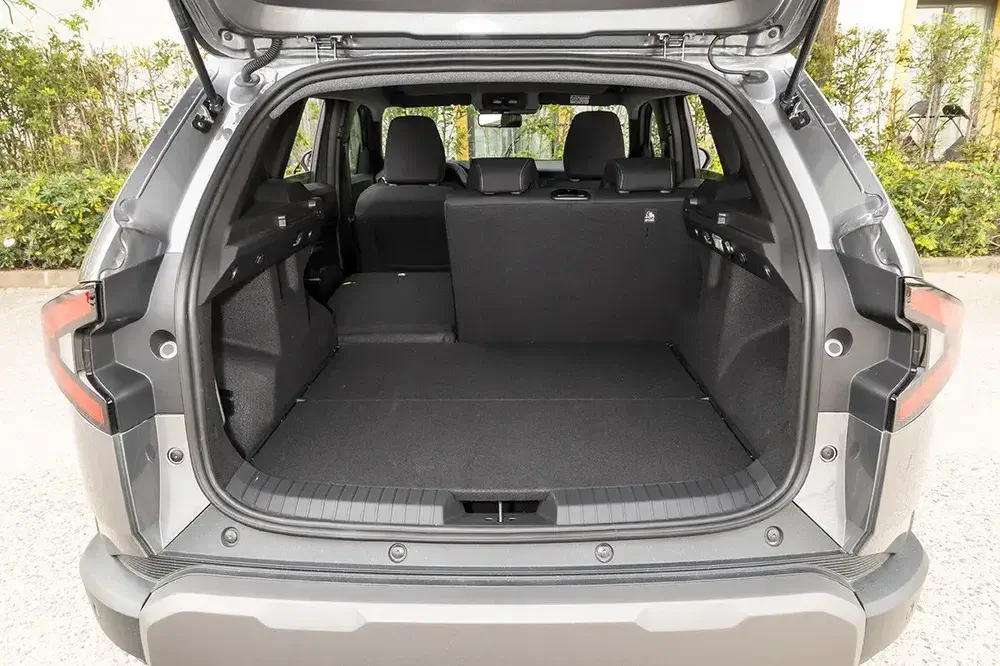 Coffre spacieux d'un SUV Toyota RAV4 avec sièges arrière repliés.