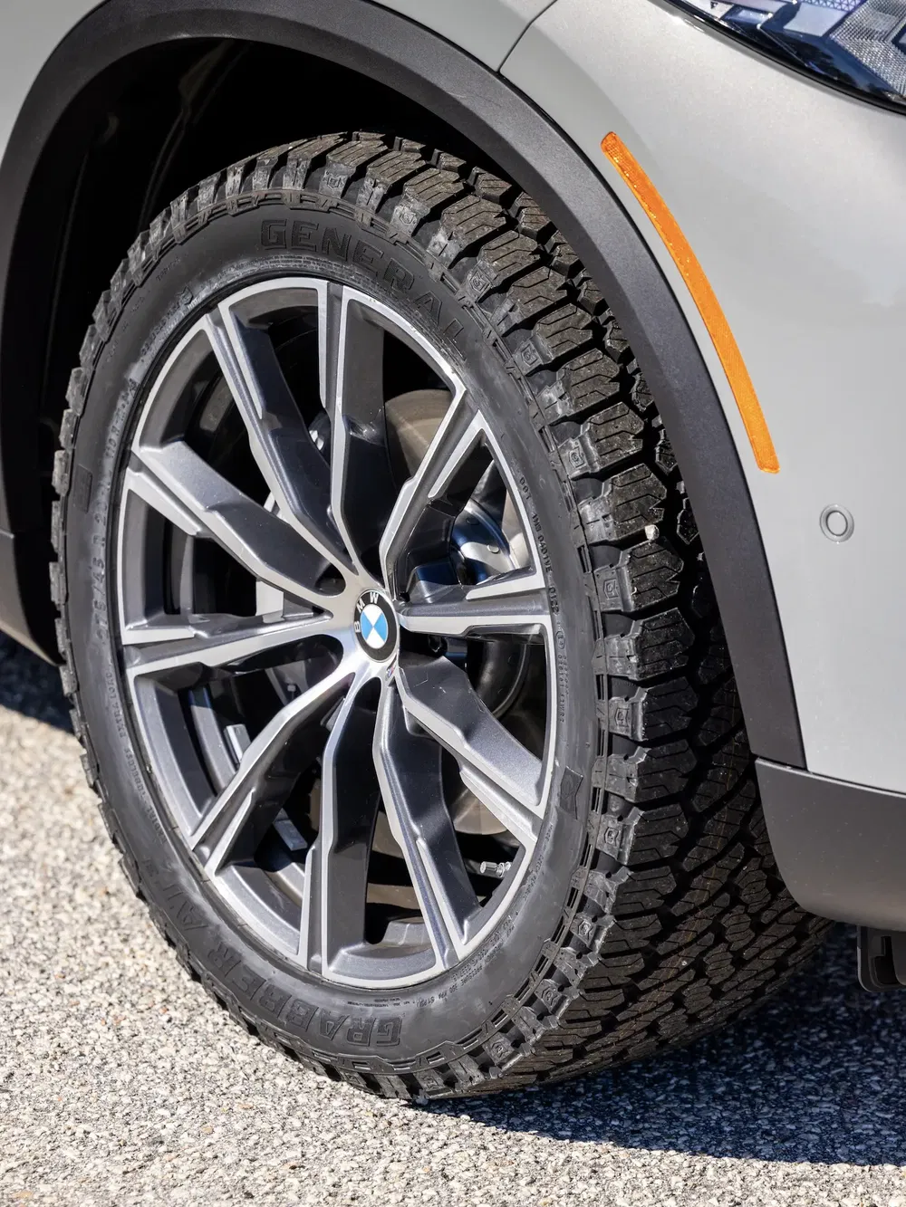 Roues BMW avec pneus hiver General Grabber sur asphalte, détails de jante et garde-boue.